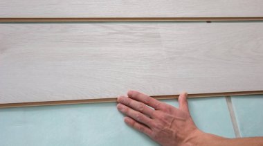 İşçilerin elleri ahşap kaplama döşeme döşemesi kuruyor. Ahşap zeminli ve ölçülü ev tadilatı. seçici odak