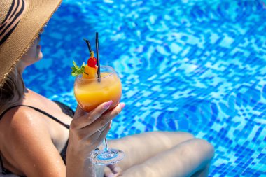 Kız havuzda kokteyl içiyor. Doğa. seçici odak