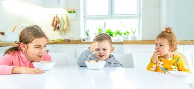 Çocuklar mutfaktaki masada makarna çeviriyor. seçici odak