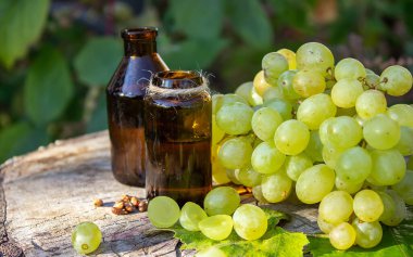 Cam kavanozda üzüm tohumu yağı ve kaplıca ve vücut bakımı için taze üzüm. Spa, biyoloji, ekolojik ürünler konsepti. seçici odak