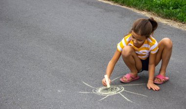 Çocuk kaldırıma tebeşirle çizer, kalp güneştir. Doğa. seçici odak
