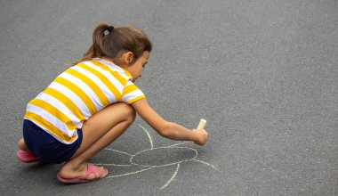 Çocuk kaldırıma tebeşirle çizer, kalp güneştir. Doğa. seçici odak