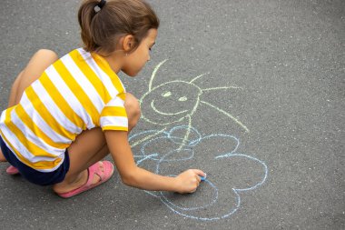 Çocuk kaldırıma tebeşirle çizer, kalp güneştir. Doğa. seçici odak