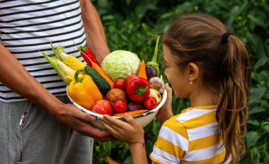 Çocuk ve baba ellerinde taze sebzeler tutuyor. Seçici odaklanma. Çocuk.