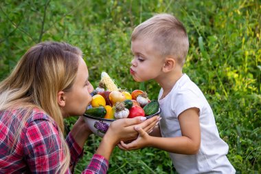 Bahçedeki çocuk elinde sebzelerle. Seçici odaklanma. Doğa.