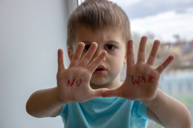 Küçük bir çocuğun avuçlarında savaşa hayır yazan bir yazı var. seçici odak