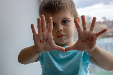 Küçük bir çocuğun avuçlarında savaşa hayır yazan bir yazı var. seçici odak