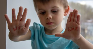 Küçük bir çocuğun avuçlarında savaşa hayır yazan bir yazı var. seçici odak