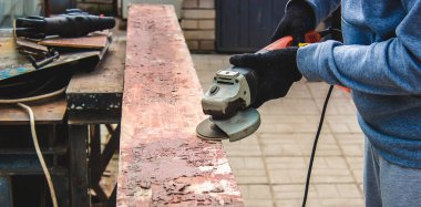 Bir adam tahtayı öğütüyor. Tahtalardan eski boyaları çıkarıyorum. Marangozluk işi. seçici odak