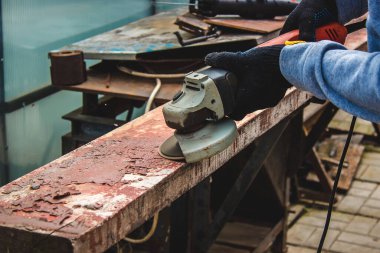 Bir adam tahtayı öğütüyor. Tahtalardan eski boyaları çıkarıyorum. Marangozluk işi. seçici odak