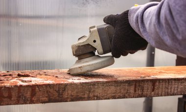 Bir adam tahtayı öğütüyor. Tahtalardan eski boyaları çıkarıyorum. Marangozluk işi. seçici odak