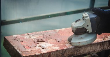 Bir adam tahtayı öğütüyor. Tahtalardan eski boyaları çıkarıyorum. Marangozluk işi. seçici odak