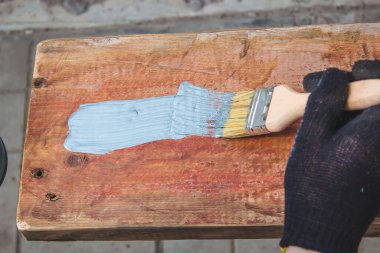 Elleriniz fırçayı tutsun, tahtaya cila sürün. tahta boyası. seçici odak