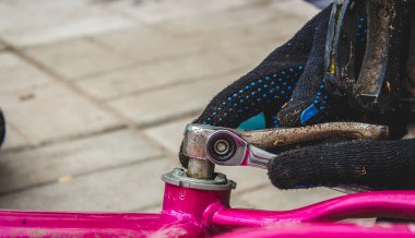 Bir baba kızının bisikletini tamir eder. seçici odak