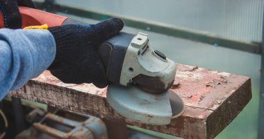 Bir adam tahtayı öğütüyor. Tahtalardan eski boyaları çıkarıyorum. Marangozluk işi. seçici odak