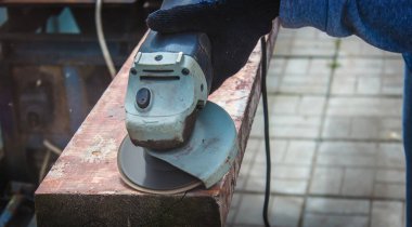 Bir adam tahtayı öğütüyor. Tahtalardan eski boyaları çıkarıyorum. Marangozluk işi. seçici odak