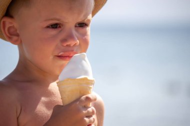 Çocuk ağlıyor ve sahilde dondurma yiyor. seçici odak