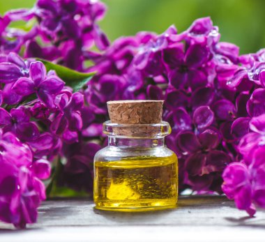 Küçük bir şişedeki leylak yağı. Seçici odaklanma. Doğa.
