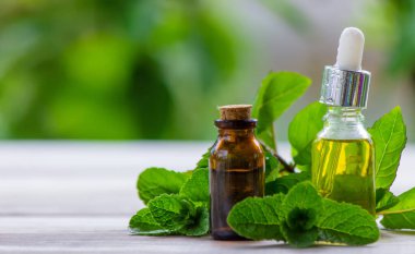 Küçük bir şişede nane yağı. Seçici odaklanma. Doğa.