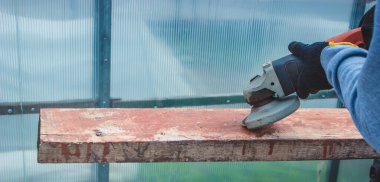 Bir adam tahtayı öğütüyor. Tahtalardan eski boyaları çıkarıyorum. Marangozluk işi. seçici odak