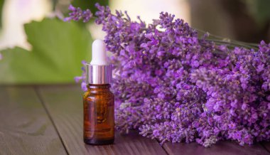 Ahşap bir arka planda lavanta yağı var. seçici odak