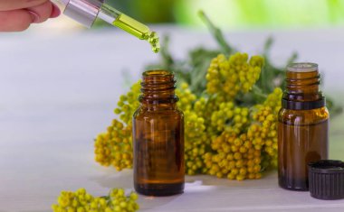 Bottle with essential oil of tansy extract, tincture. The concept of aromatherapy, spa and herbal medicine. selective focus