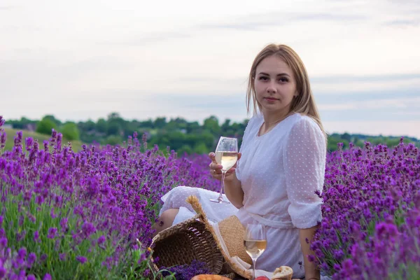 Bir Kız Lavanta Tarlasının Arka Planında Bir Bardak Beyaz Şarap — Stok fotoğraf