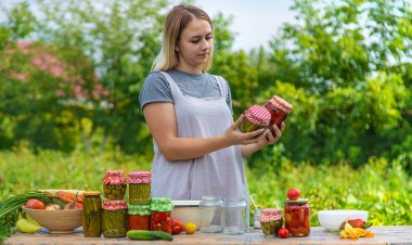 A woman preserves vegetables in jars. Selective focus. Food.