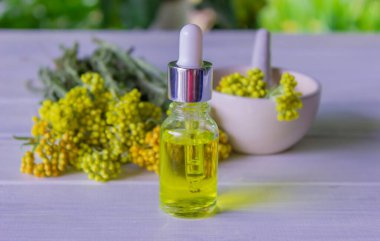 essential oil of tansy in a beautiful bottle on the table. selective focus