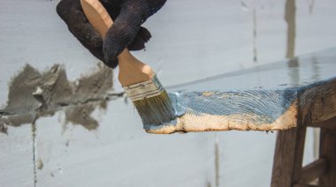 Ağacı griye boyayan fırçalı bir el. seçici odak