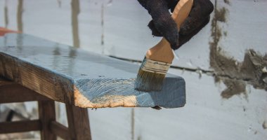 Ağacı griye boyayan fırçalı bir el. seçici odak