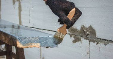 Ağacı griye boyayan fırçalı bir el. seçici odak