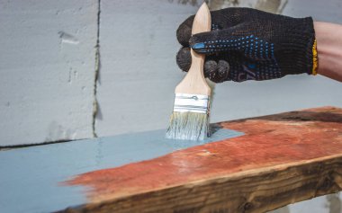 Ağacı griye boyayan fırçalı bir el. seçici odak