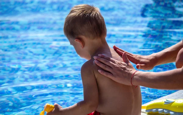 mother smears the child with sunscreen. selective focus