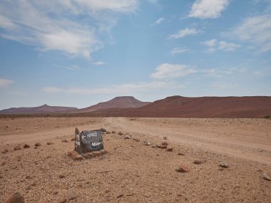 Damarland Namibya 'nın kurak bölgesinde yol işareti Hoanib ve Aub Kanyonu' nu gösteriyor.