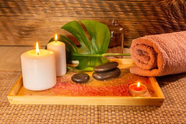 Spa, zen bazalt taşları, havlular, mumlar masaj odasındaki ahşap tepside..