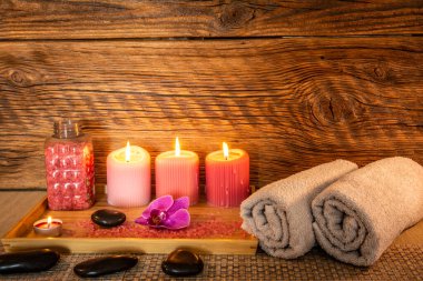 Spa, zen bazalt taşları, havlular, mumlar masaj odasındaki ahşap tepside..