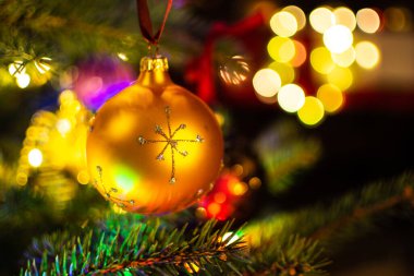 Christmas decorations on the Christmas tree illuminated with colorful lights.