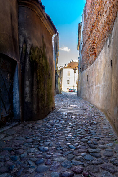 Lublin, Lubelskie Voivodeship Poland - July 10 2022: an old narrow street in Lublin, towards the parish church.