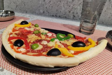 Pizzanın yarısı parçalanmış, yemeye hazır.