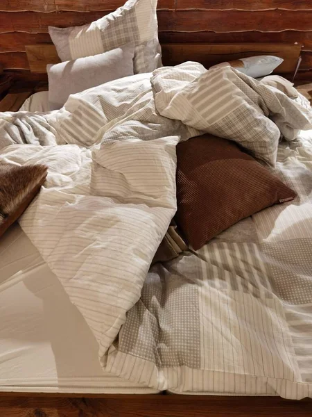Una Cama Que Está Ordenada Con Una Manta Almohada — Foto de Stock