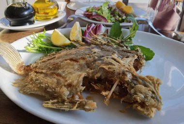 Beyaz tabakta servis edilen ızgara balık.