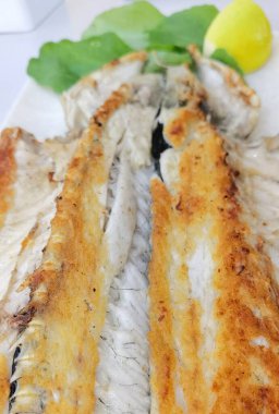 Kızarmış balık, yanında birkaç meze, ızgara altın kahverengisi.