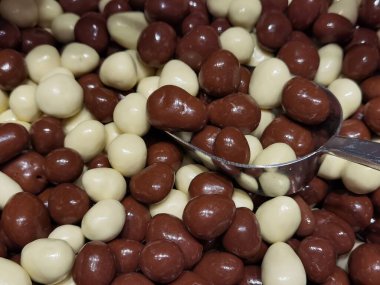 Beyaz çikolata ve acı çikolatayla kaplı fıstıklar.