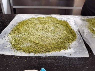 Hamur, peynir ve şam fıstığı içeren Türk Katmer tatlısının hazırlanması..