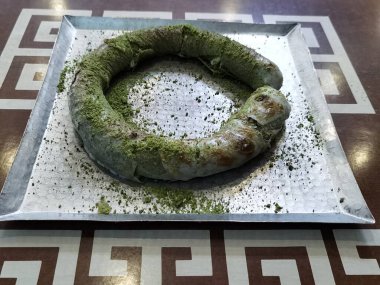 Hamur, peynir ve şam fıstığı içeren Türk Katmer tatlısının hazırlanması..