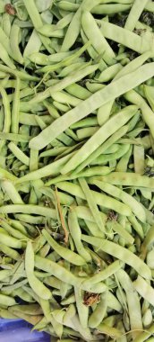 Birbirinin üstünde yeşil fasulye sapları var.