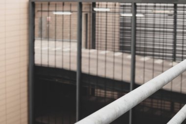 Demir parmaklıkların ardındaki bulanık hapishane duvarının görüntüsü. Seçici odak.