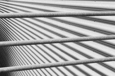 Metal elementlerin soyut arkaplanı. Paslanmaz çelik borular ve dalgalı demir levha dokusu. Yumuşak odak.