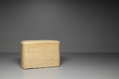 Gri arka planda açısal ahşap briketi. Kozalaklı ve yaprak döken ağaç talaşlarından katı yakıtlar..